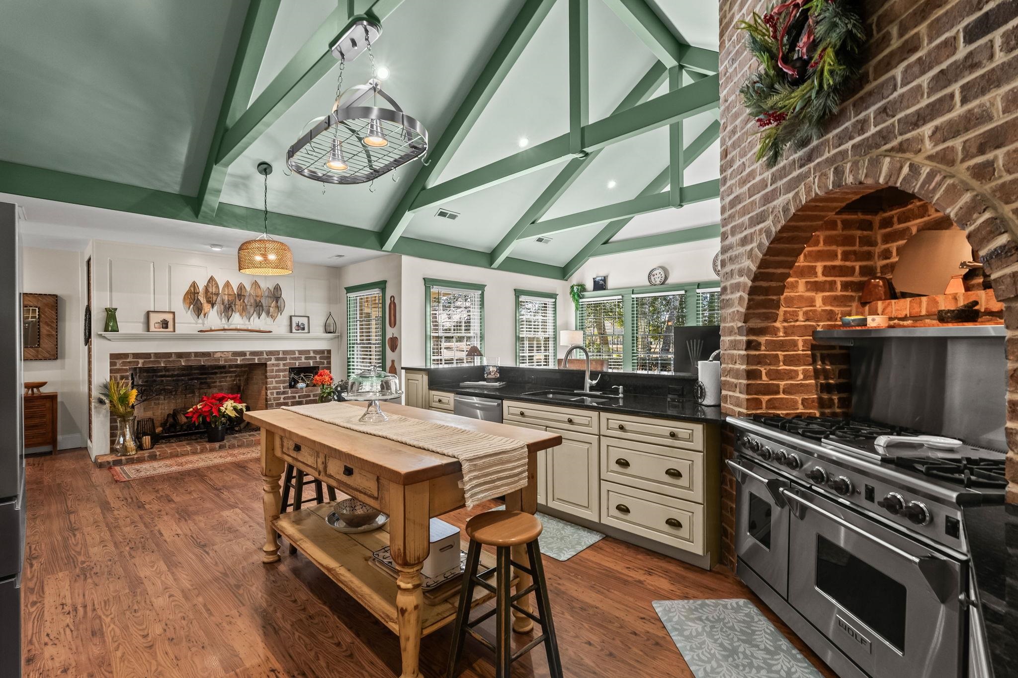 400 Foxtail Drive Longs, SC 29568 - Photo 19 of 40 Kitchen featuring stainless steel appliances, high vaulted ceiling, beam ceiling, a fireplace, and dark wood-style floors