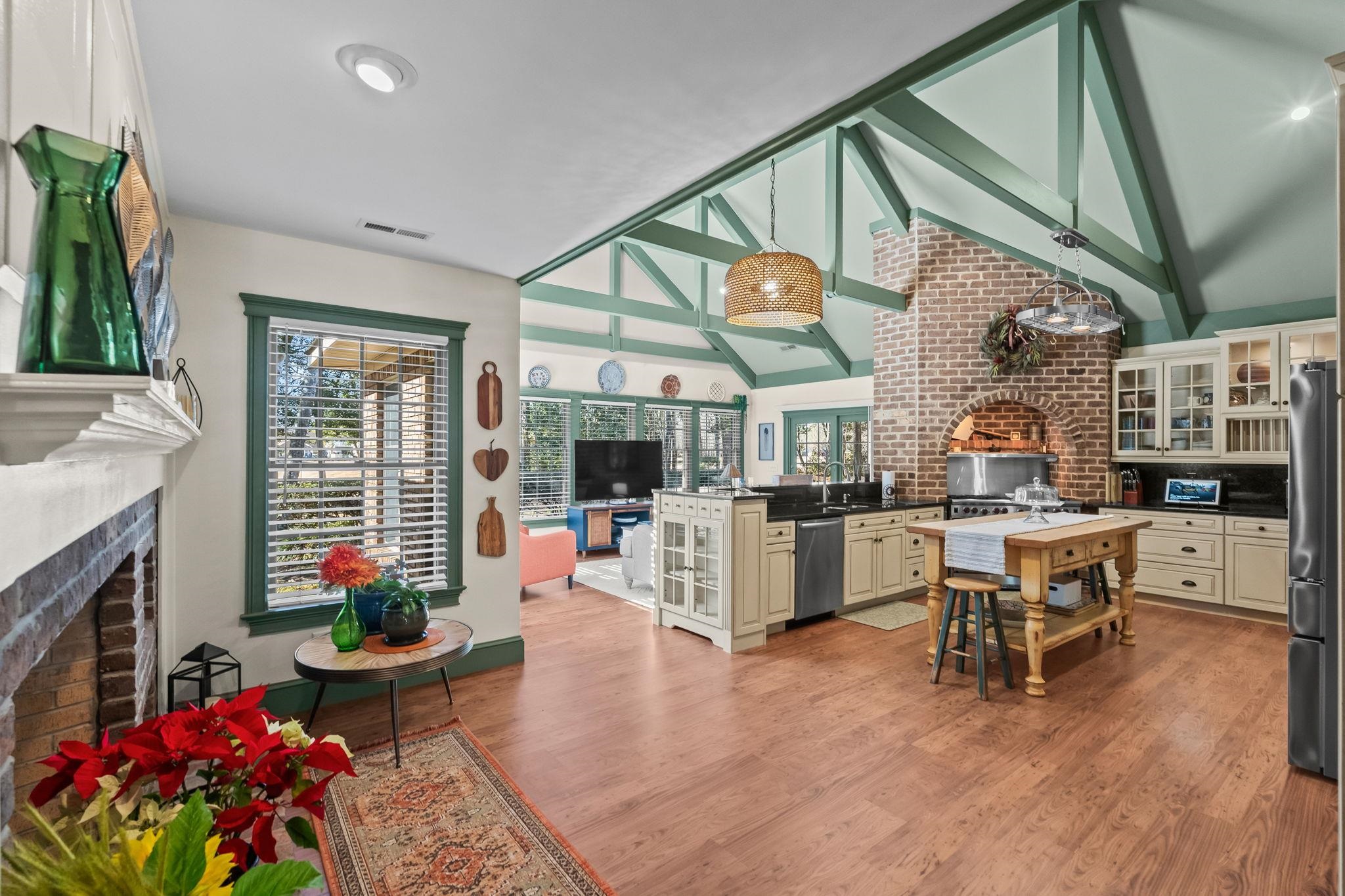 400 Foxtail Drive Longs, SC 29568 - Photo 8 of 40 Kitchen with a fireplace, glass insert cabinets, beamed ceiling, hanging light fixtures, and light wood finished floors