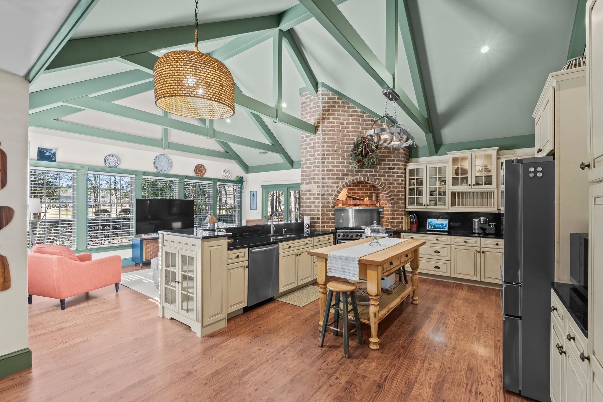 400 Foxtail Drive Longs, SC 29568 - Photo 9 of 40 Kitchen with glass insert cabinets, high vaulted ceiling, cream cabinetry, decorative light fixtures, and appliances with stainless steel finishes