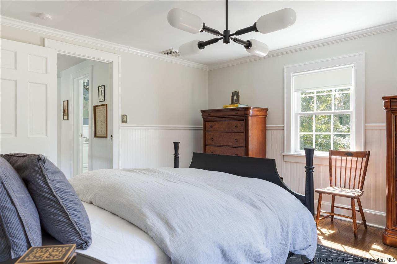 1162 Plains Road Wallkill, NY 12589 - Photo 7 of 35 a bedroom with a bed and a chandelier