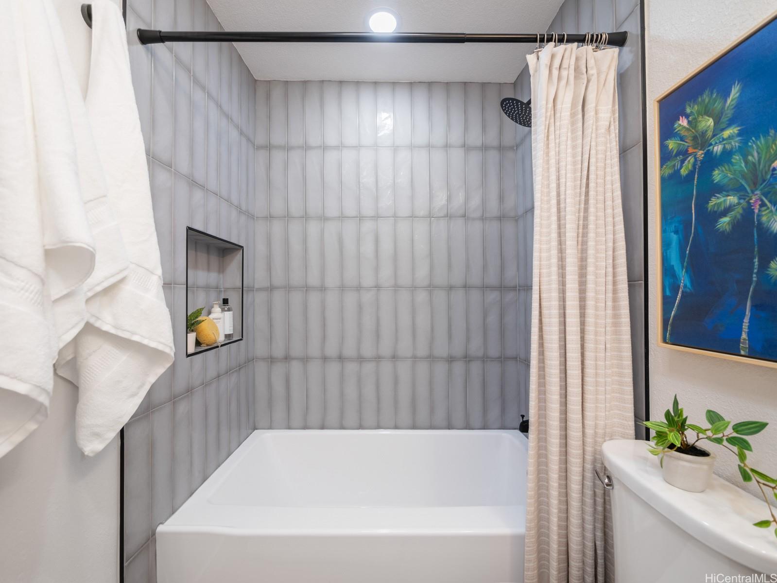 95-664 Wikao Street, Unit L205 Mililani, HI 96789 - Photo 11 of 25 a bathroom with a bathtub and shower