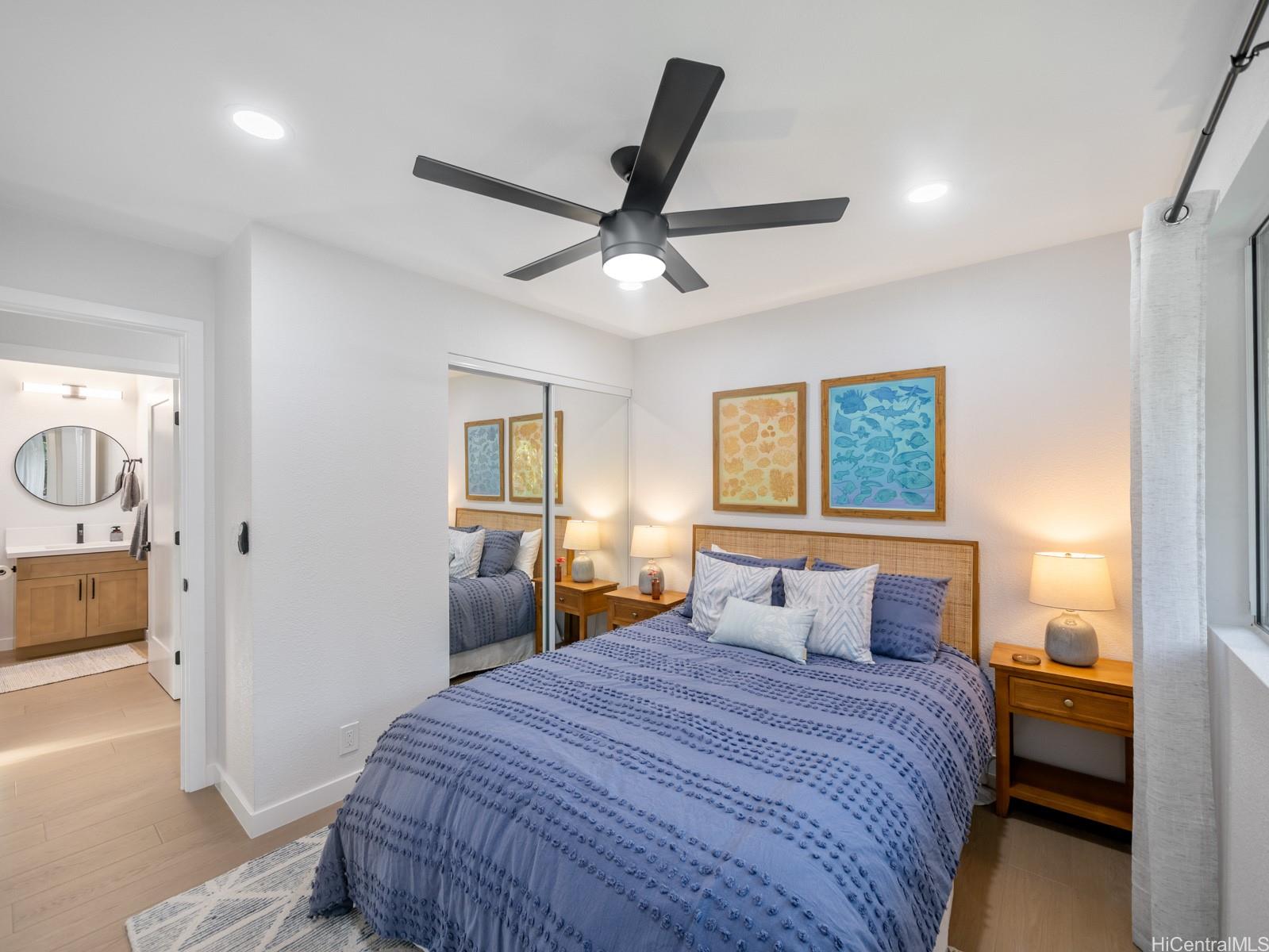 95-664 Wikao Street, Unit L205 Mililani, HI 96789 - Photo 8 of 25 a bedroom with a large bed and a chandelier