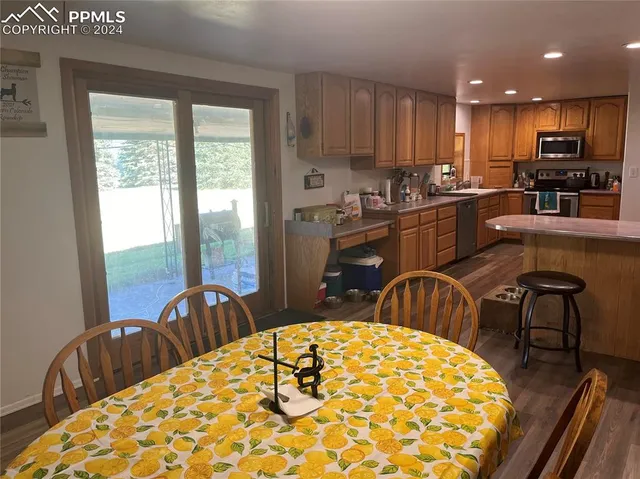 a kitchen with stainless steel appliances granite countertop a refrigerator a stove top oven a sink dishwasher and white cabinets with wooden floor