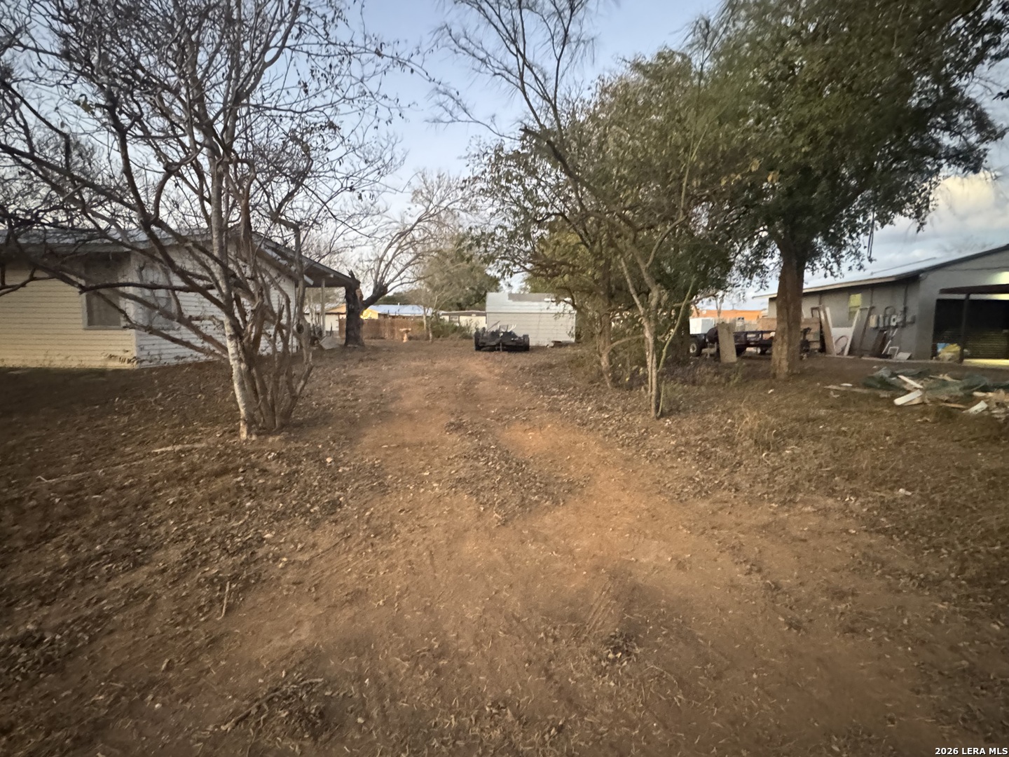 504 North Cedar Street Pearsall, TX 78061 - Photo 21 of 23 a backyard of a house with large trees and a barn