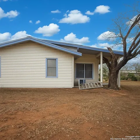 a view of a house with a yard and potted plants