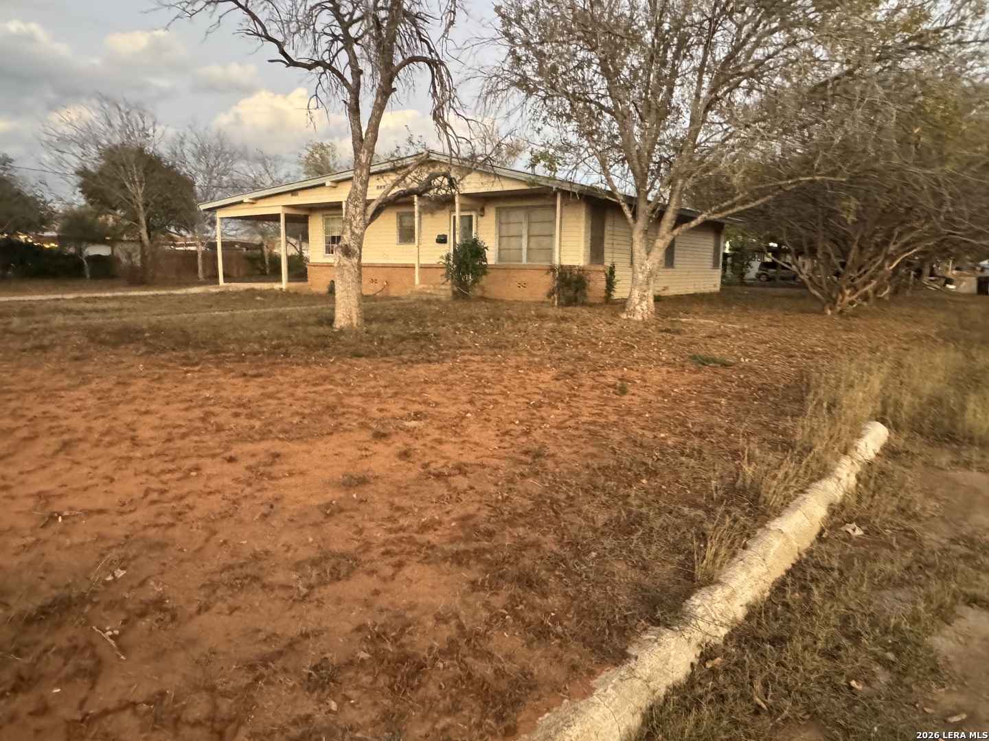 504 North Cedar Street Pearsall, TX 78061 - Photo 4 of 23 a view of a yard in front of a house with large trees