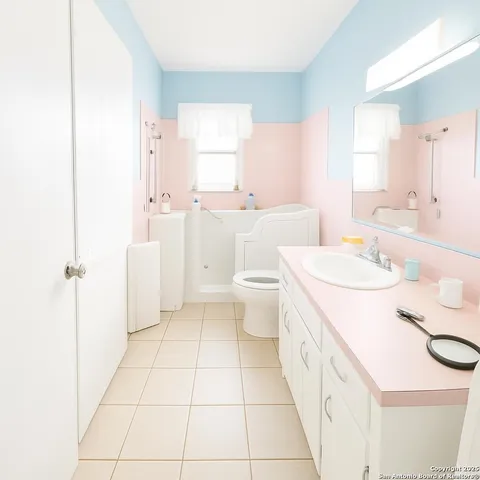 a spacious bathroom with a sink a toilet and a mirror