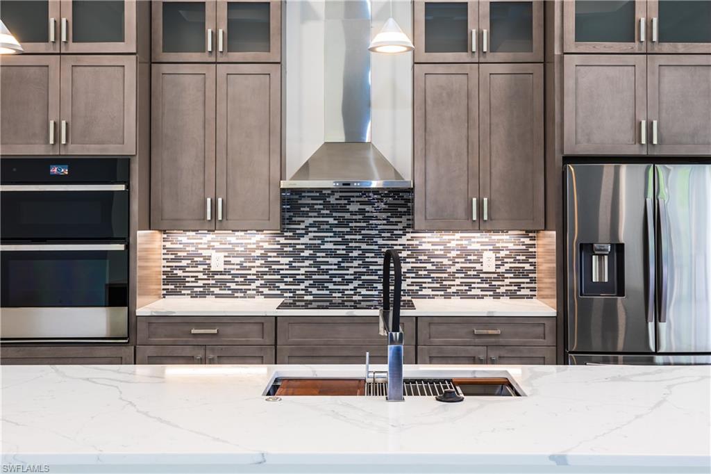 231 Legacy Court Naples, FL 34110 - Photo 11 of 35 a kitchen with wooden cabinet and a counter top space