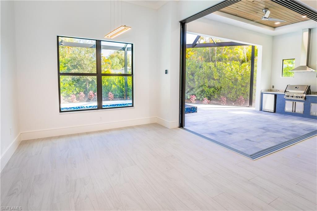 231 Legacy Court Naples, FL 34110 - Photo 15 of 35 a view of an empty room with wooden floor and a window