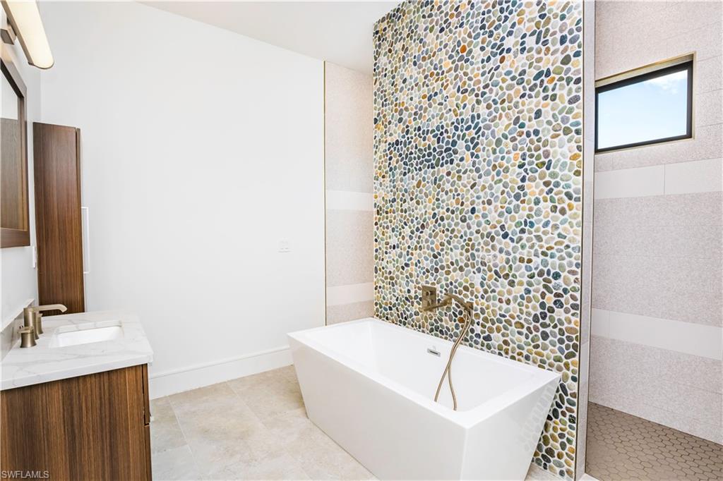 231 Legacy Court Naples, FL 34110 - Photo 31 of 35 a bathroom with a bathtub and shower