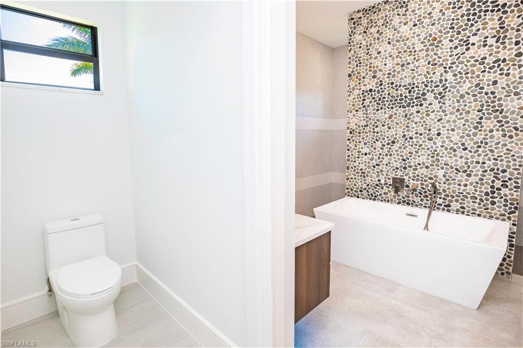 231 Legacy Court Naples, FL 34110 - Photo 33 of 35 a bathroom with a toilet and a bathtub