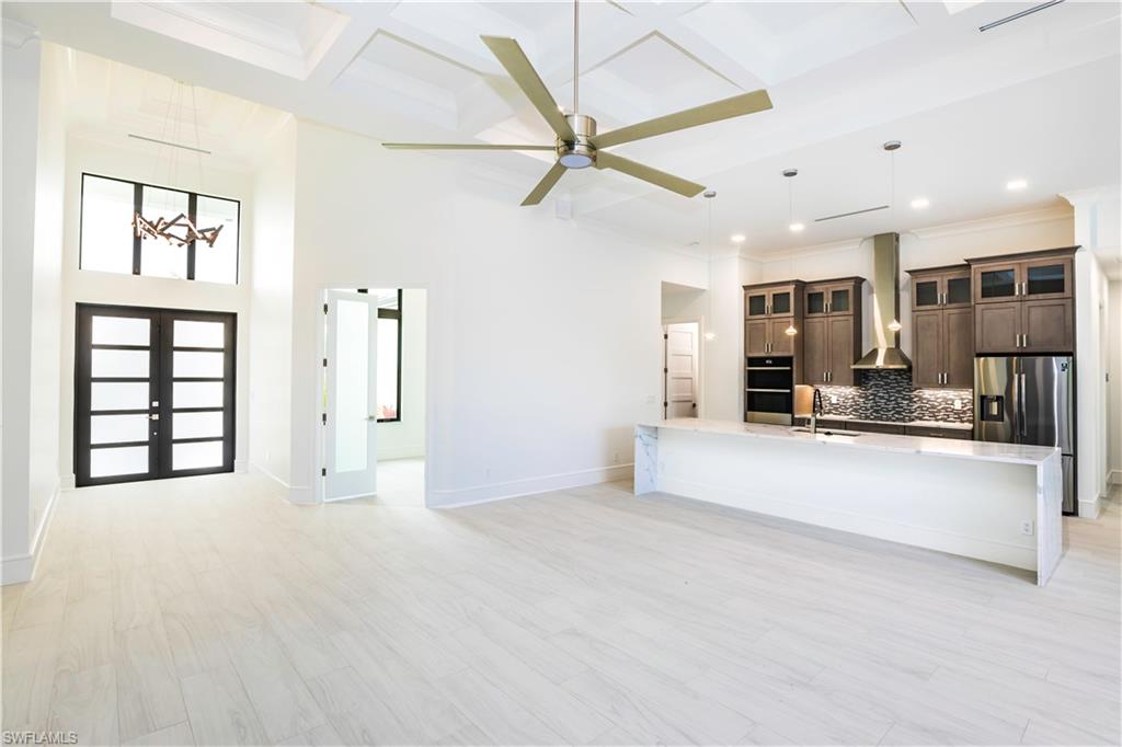231 Legacy Court Naples, FL 34110 - Photo 10 of 35 a view of an empty room with kitchen and a window