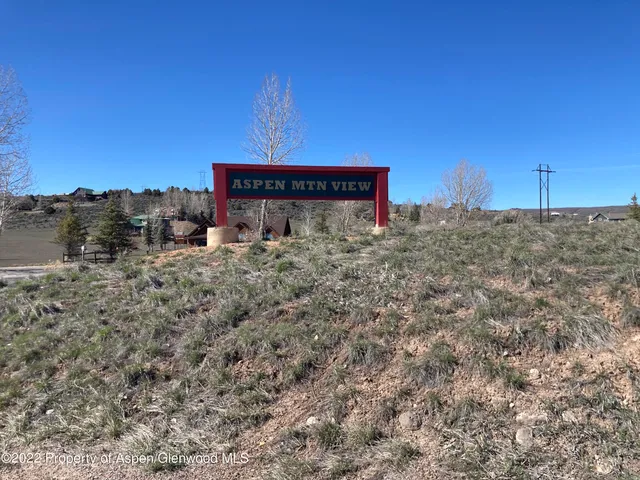 a view of a dry yard with wooden fence