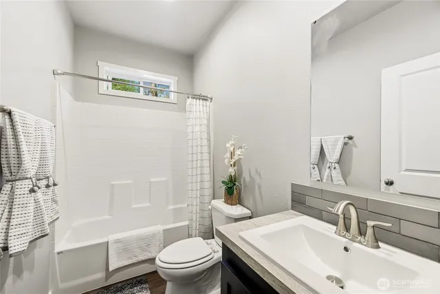 a kitchen with stainless steel appliances a dining table chairs refrigerator and microwave