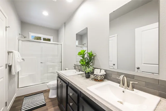 a bathroom with a granite countertop sink a toilet and shower