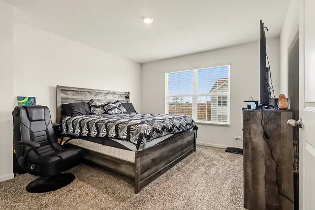 a bedroom with a bed next to a window