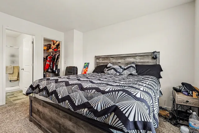 a bedroom with bed and a painting on the wall