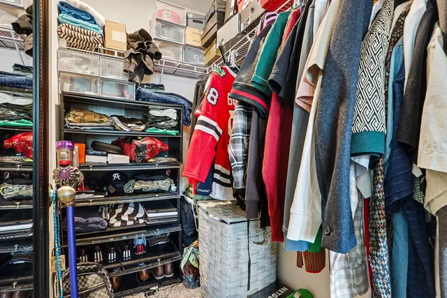 a view of walk in closet with clothes and shoes
