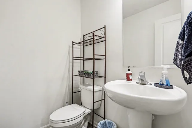 a bathroom with a sink toilet and mirror