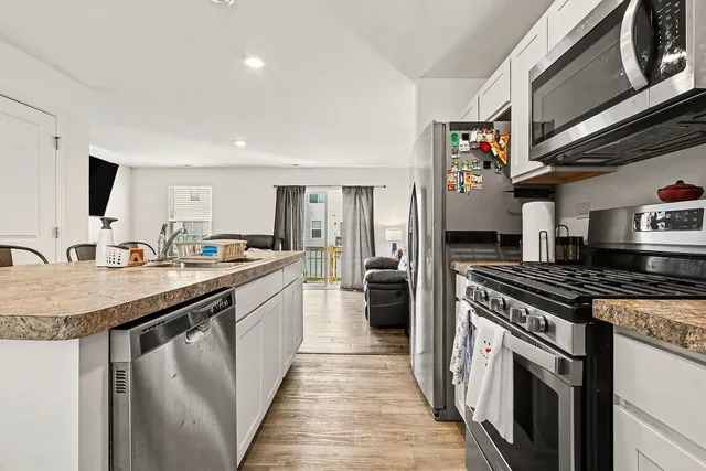 a kitchen with granite countertop a sink stainless steel appliances and cabinets
