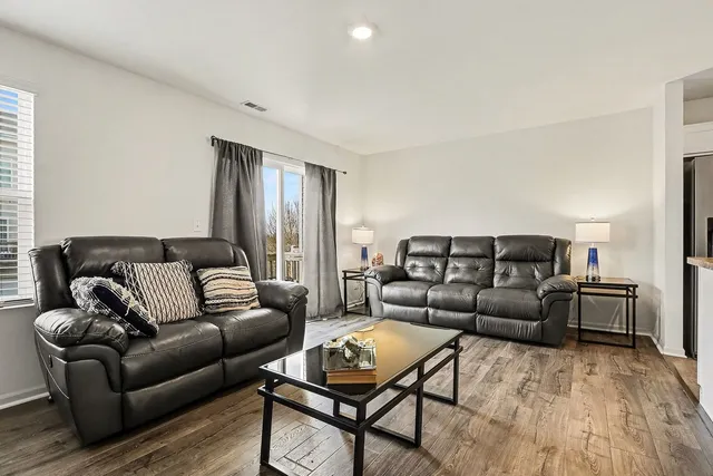 a living room with furniture and a wooden floor