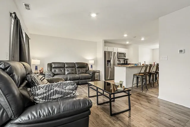 a living room with furniture and kitchen view