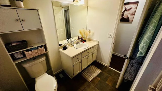 a bathroom with a sink mirror vanity and toilet