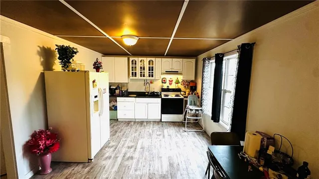 a kitchen with stainless steel appliances wooden floor and a refrigerator
