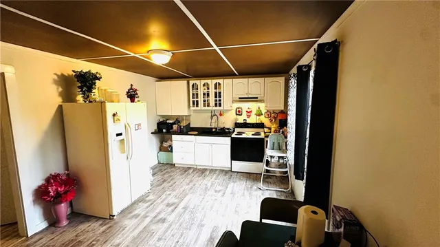 a kitchen with stainless steel appliances wooden floor and refrigerator