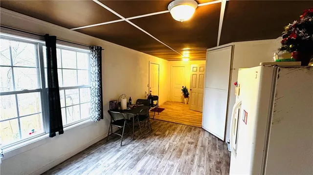 a view of a hallway with wooden floor and furniture
