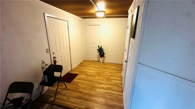 a bedroom with wooden floor and a potted plant