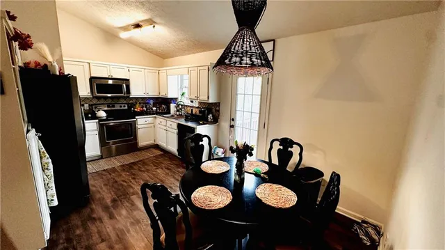a kitchen with stainless steel appliances granite countertop a stove refrigerator and a sink