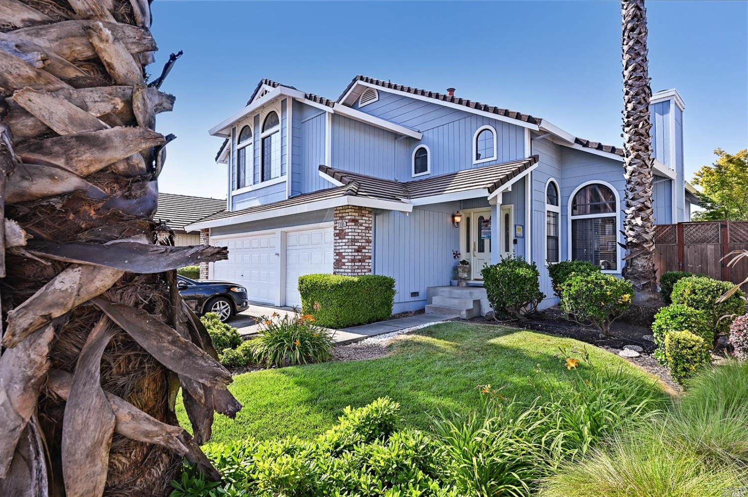 a front view of a house with garden and plants