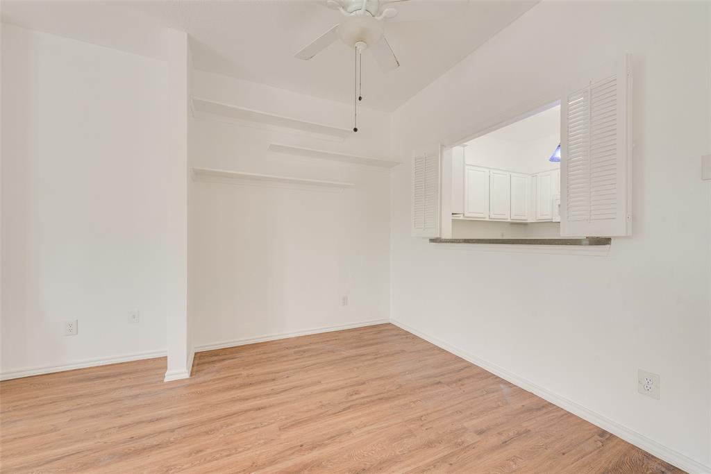 14277 Preston Road, Unit 823 Dallas, TX 75254 - Photo 9 of 25 an empty room with wooden floor and cabinet