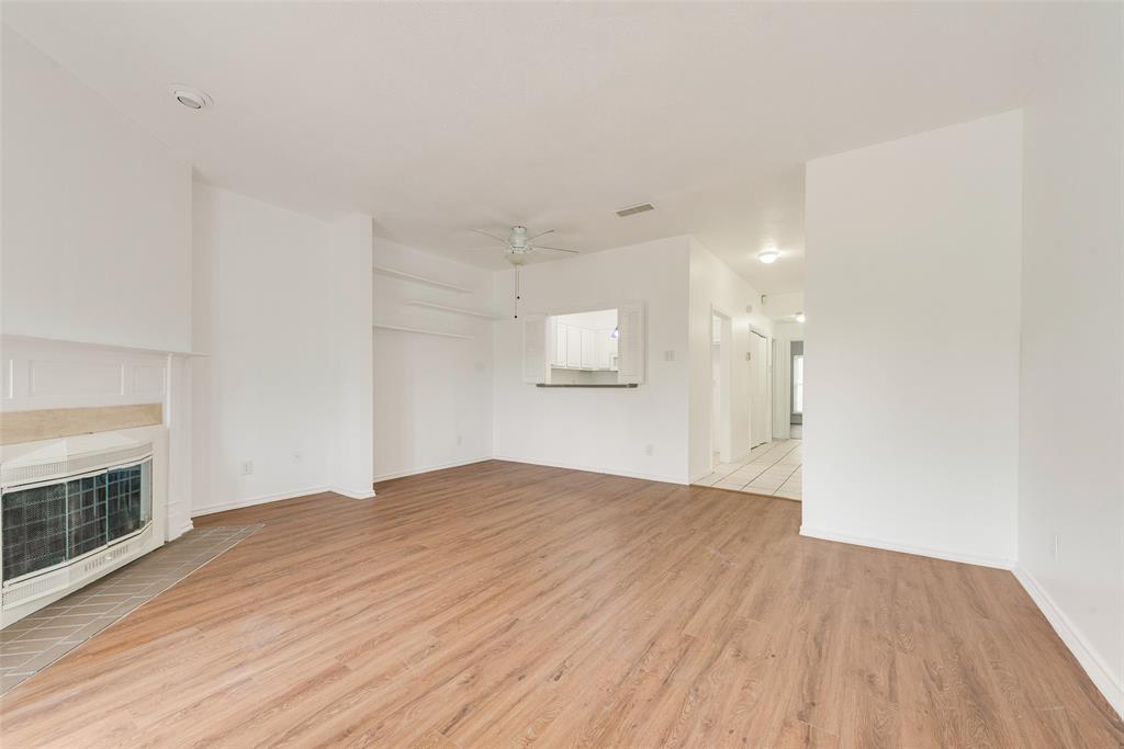 14277 Preston Road, Unit 823 Dallas, TX 75254 - Photo 10 of 25 a view of empty room with wooden floor and fireplace