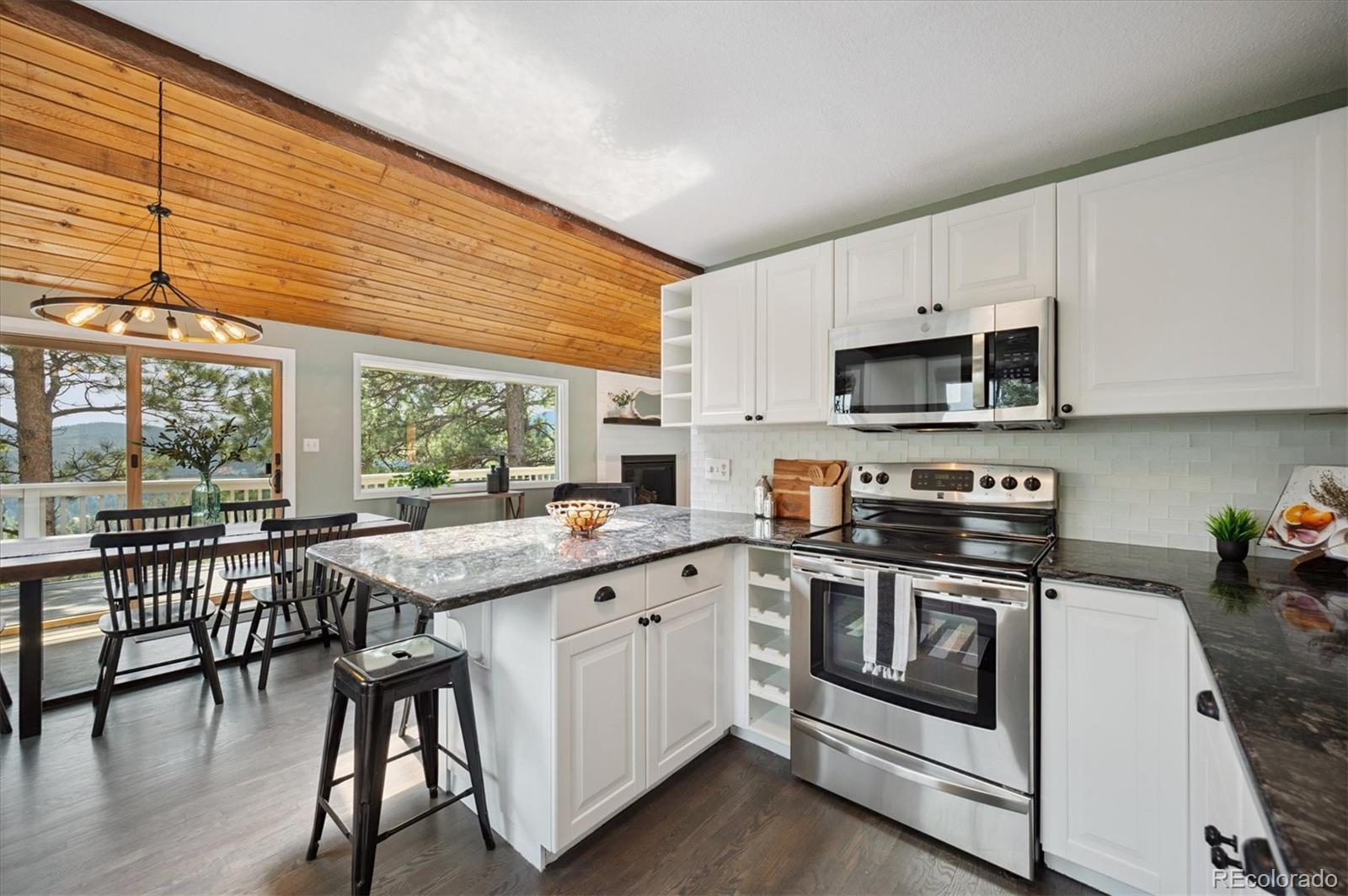 9189 Fallen Rock Road Conifer, CO 80433 - Photo 11 of 47 a kitchen with a stove a sink and cabinets
