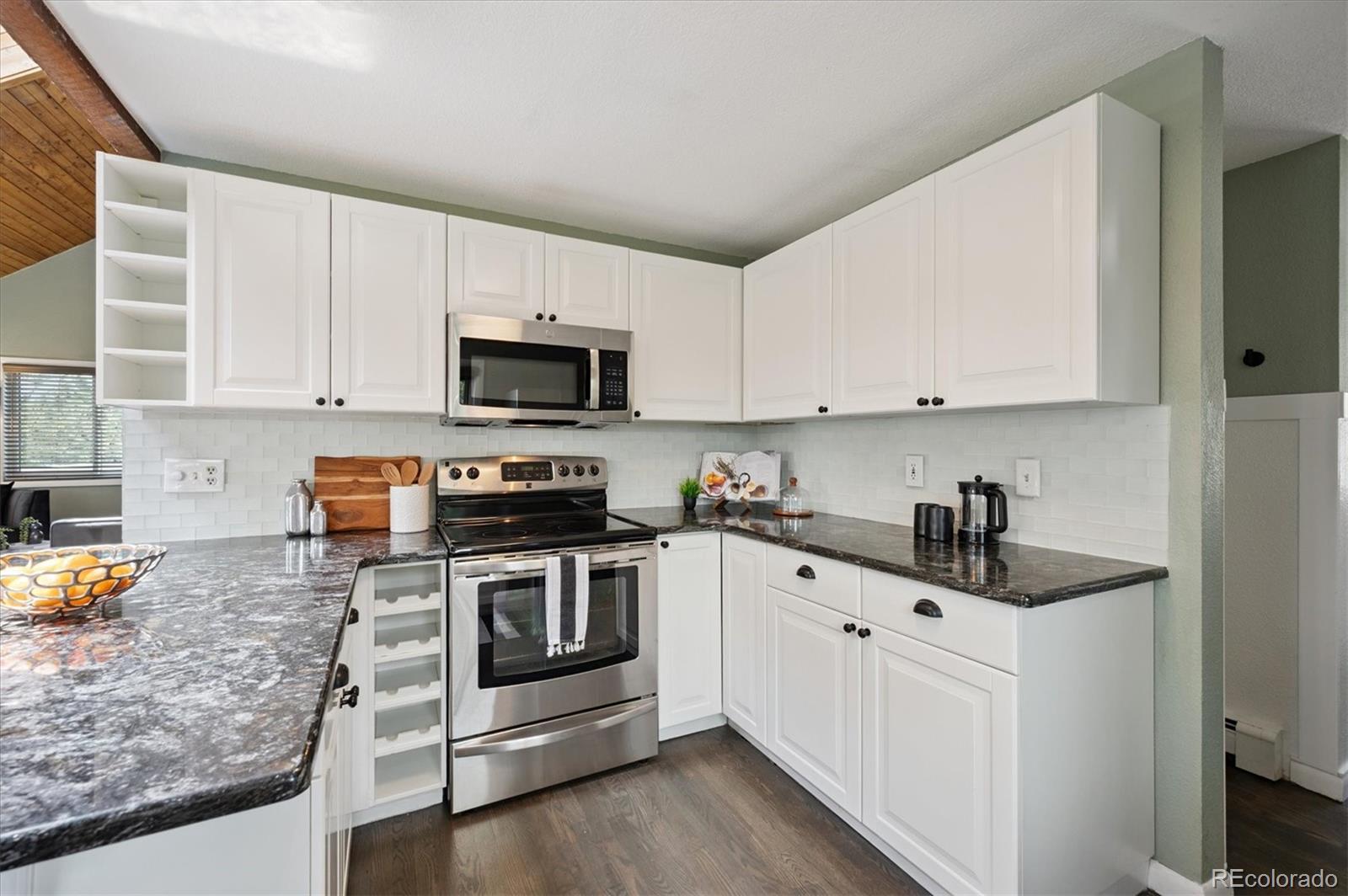9189 Fallen Rock Road Conifer, CO 80433 - Photo 12 of 47 a kitchen with stainless steel appliances granite countertop a sink stove and microwave