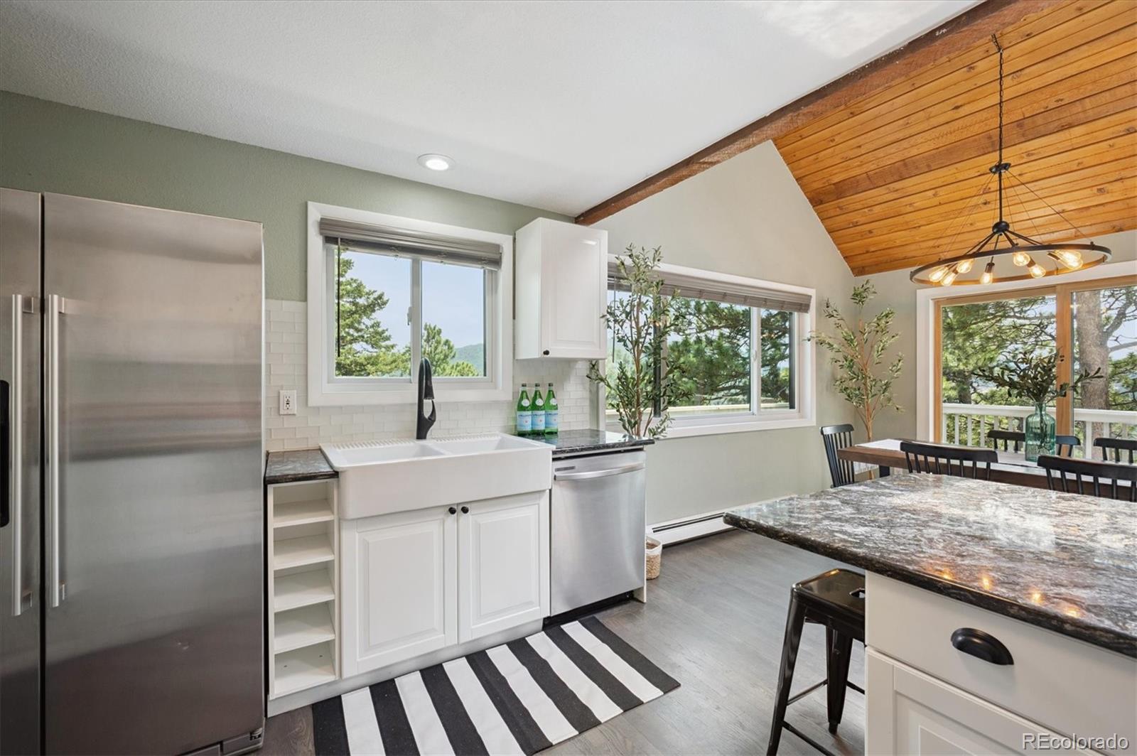 9189 Fallen Rock Road Conifer, CO 80433 - Photo 13 of 47 a kitchen with sink refrigerator and large window