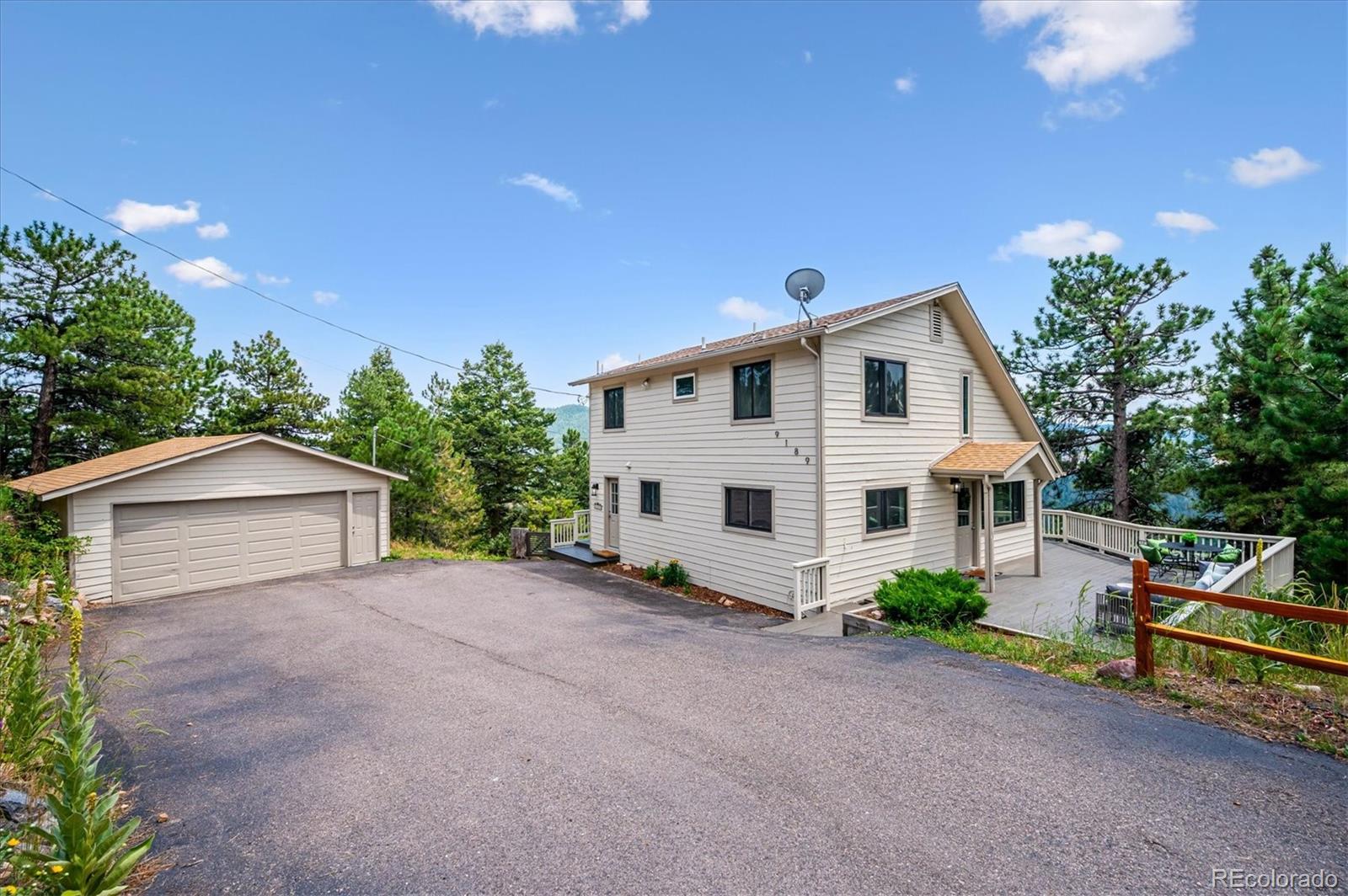 9189 Fallen Rock Road Conifer, CO 80433 - Photo 2 of 47 a front view of a house with garden