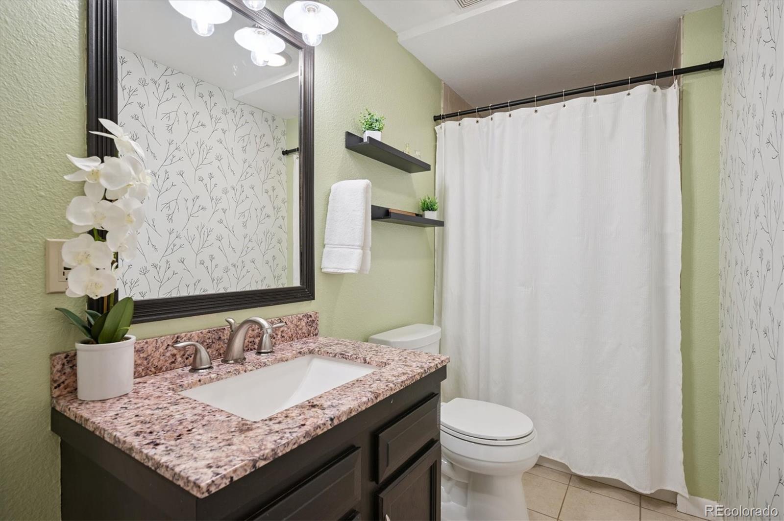 9189 Fallen Rock Road Conifer, CO 80433 - Photo 25 of 47 a bathroom with a granite countertop sink and a mirror
