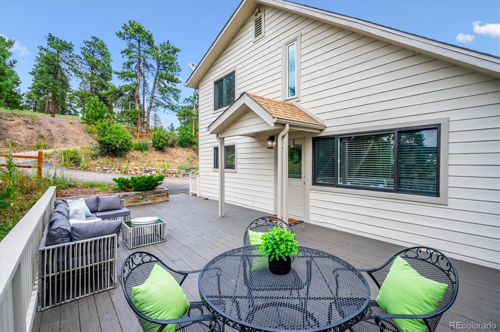 9189 Fallen Rock Road Conifer, CO 80433 - Photo 27 of 47 a front view of house with a garden and patio