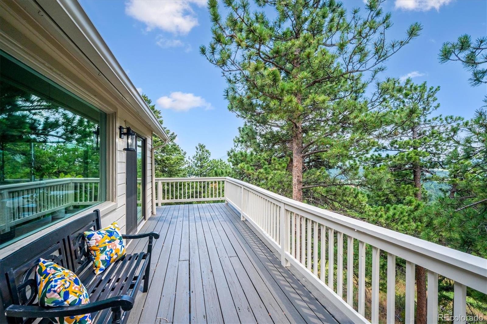 9189 Fallen Rock Road Conifer, CO 80433 - Photo 29 of 47 a view of deck with furniture and trees in the background