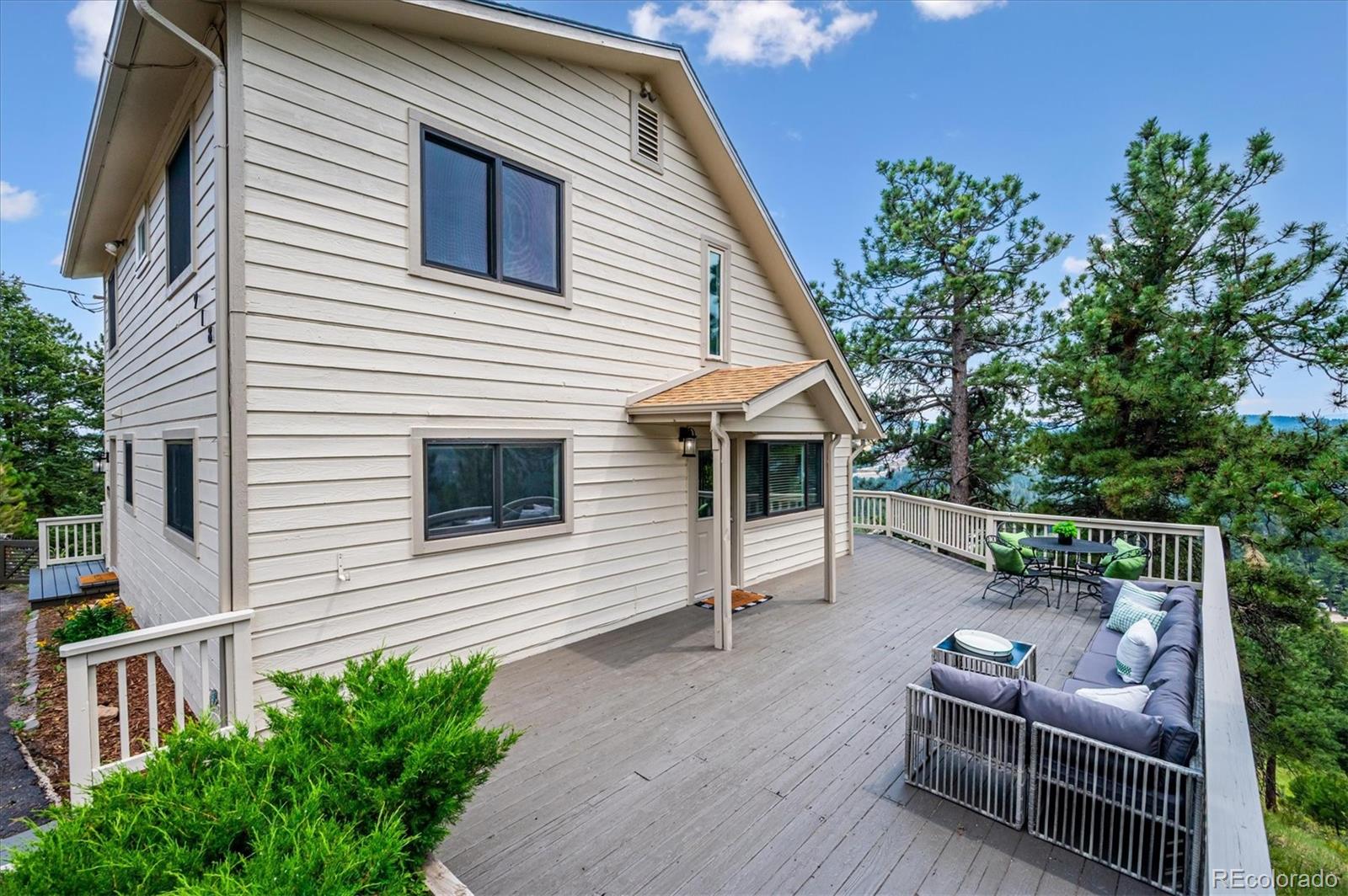 9189 Fallen Rock Road Conifer, CO 80433 - Photo 31 of 47 a terrace of a house with wooden floor and outdoor seating