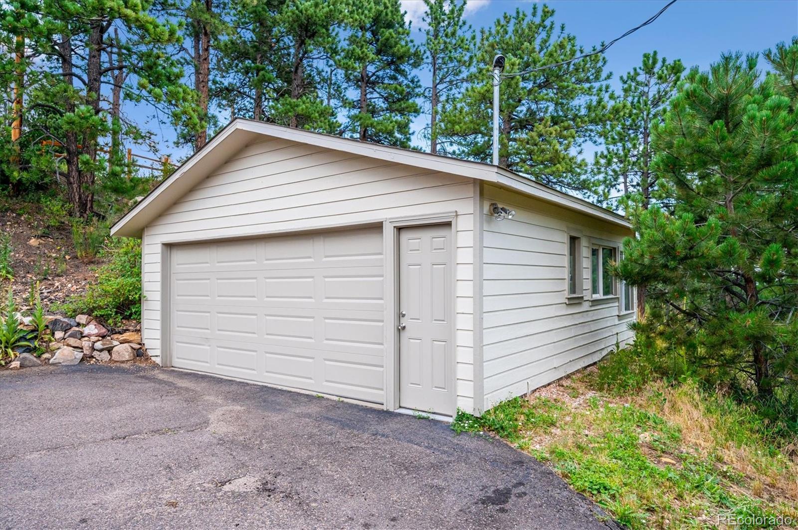 9189 Fallen Rock Road Conifer, CO 80433 - Photo 35 of 47 a view of a house with a yard and garage