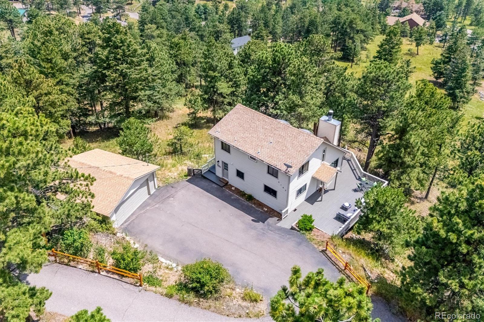 9189 Fallen Rock Road Conifer, CO 80433 - Photo 36 of 47 an aerial view of a house with a yard and greenery