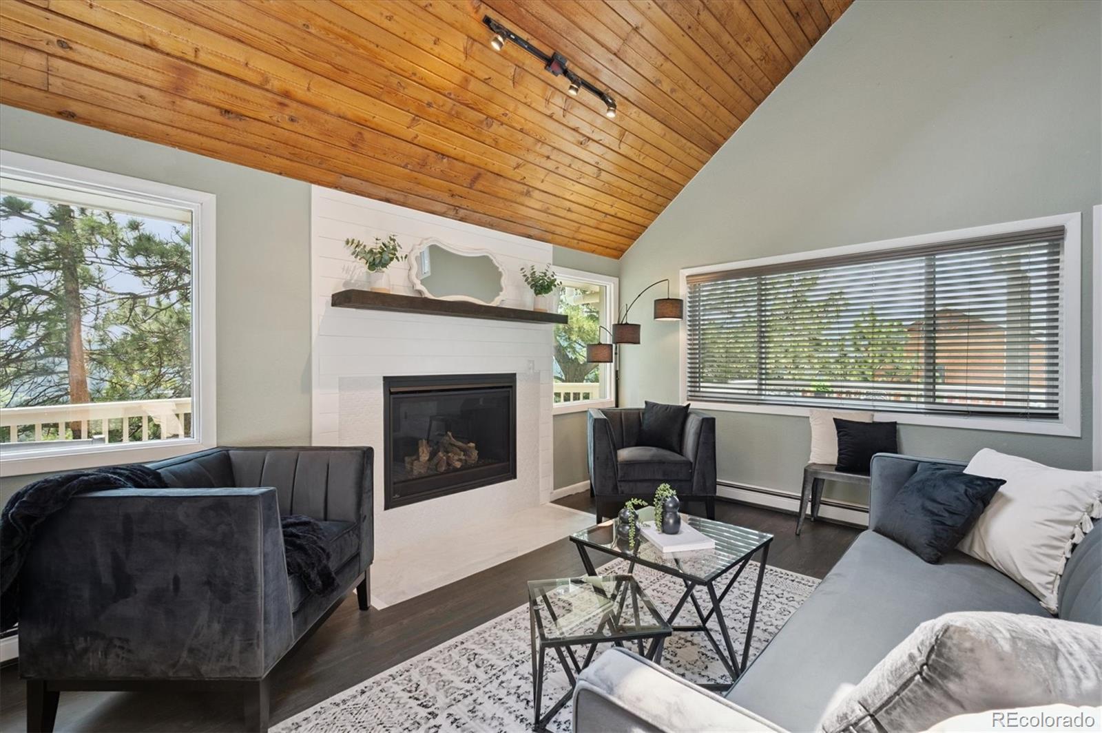 9189 Fallen Rock Road Conifer, CO 80433 - Photo 5 of 47 a living room with furniture and a fireplace