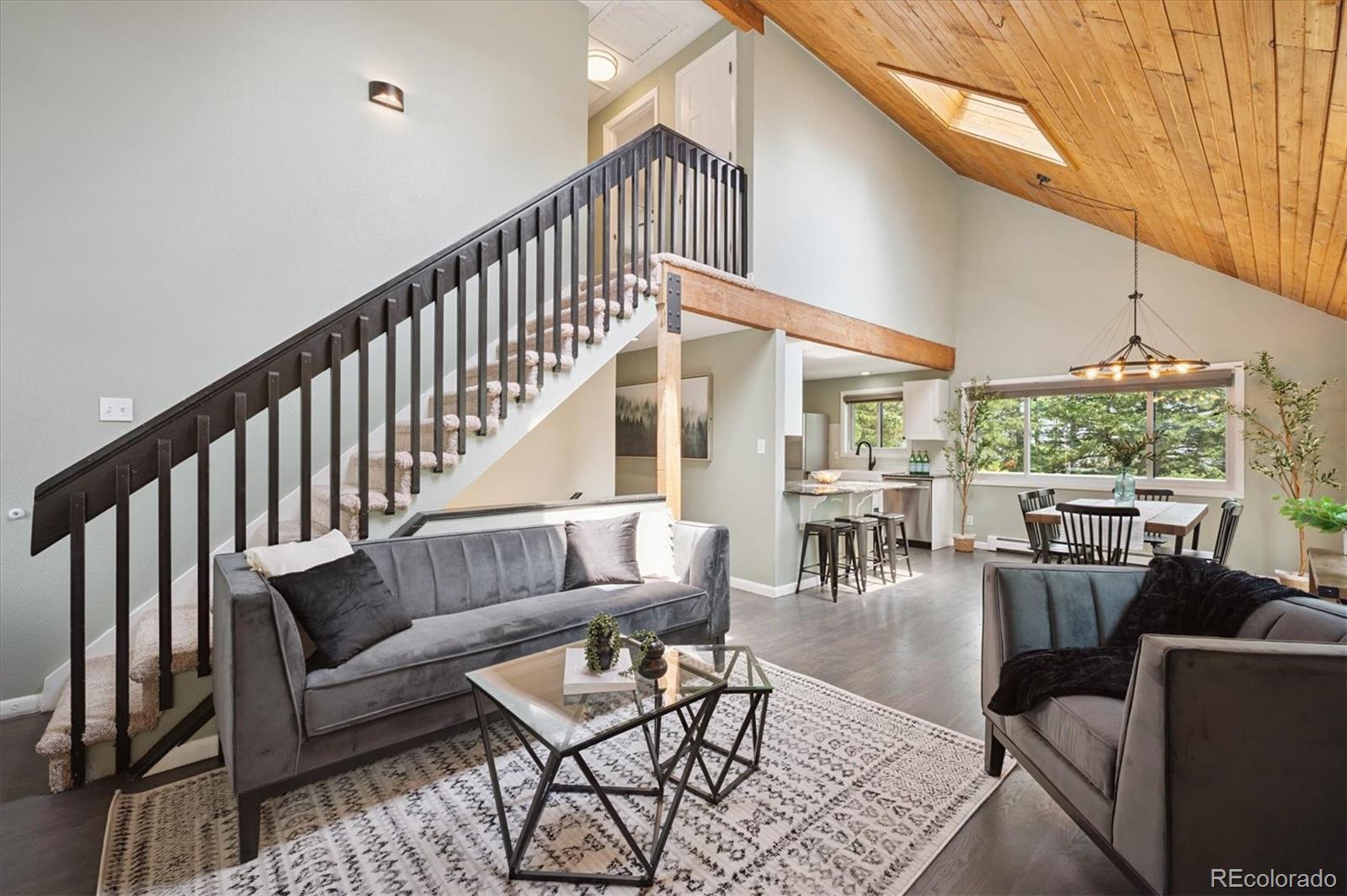 9189 Fallen Rock Road Conifer, CO 80433 - Photo 6 of 47 a living room with furniture and a table with wooden floor