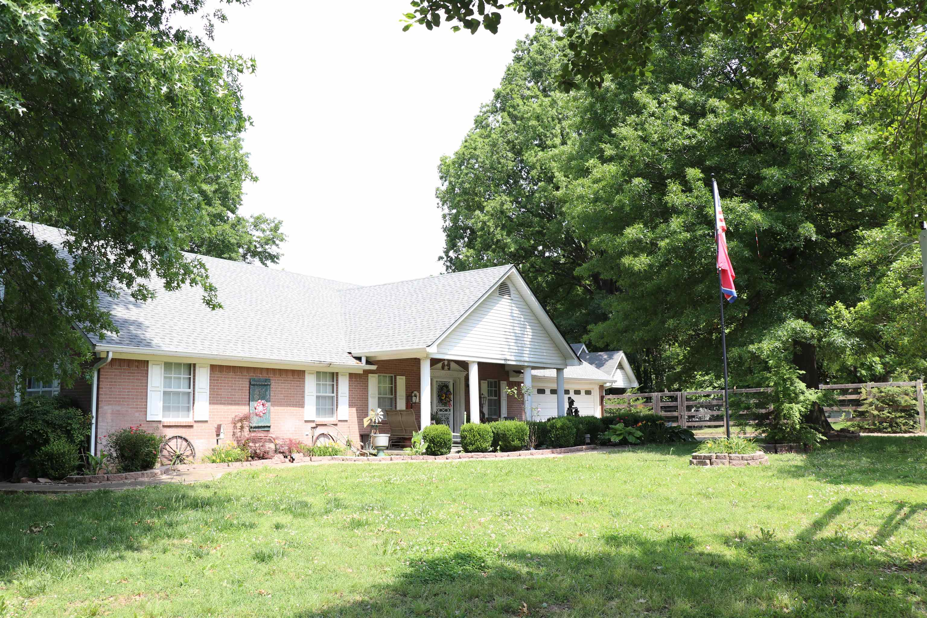 937 Kelleys Chapel Road Burlison, TN 38015 - Photo 39 of 40 Brick facade home featuring a covered front porch, white window shutters, and an attached garage