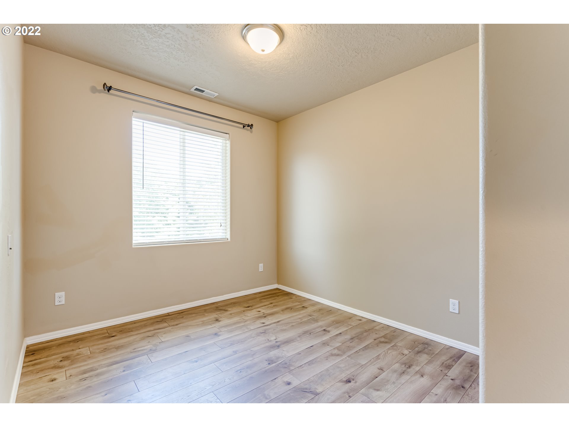 507 South 48th Place Springfield, OR 97478 - Photo 23 of 31 an empty room with wooden floor and windows