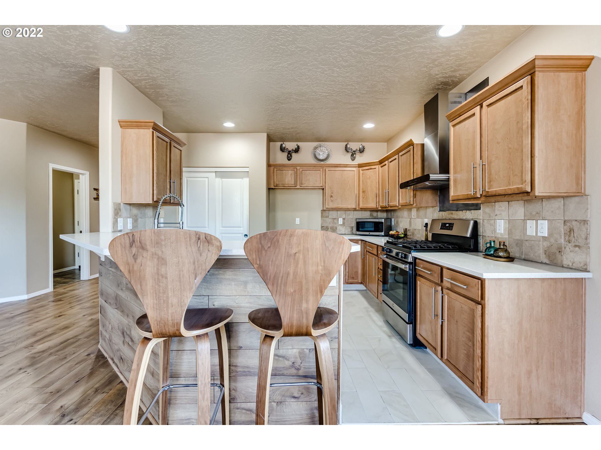 507 South 48th Place Springfield, OR 97478 - Photo 10 of 31 a kitchen with stainless steel appliances kitchen island granite countertop a refrigerator a stove a sink dishwasher with a dining table and chairs